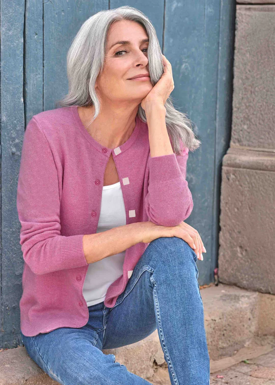Woman wears dusky pink cashmere cardigan with velcro fastening